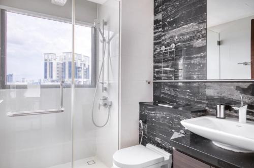 新加坡The Dapper Digs 2BR Apartment in Singapore的一间带水槽、卫生间和淋浴的浴室