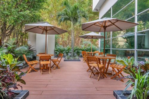 麦德林诺沃特套房酒店的一个带桌椅和遮阳伞的庭院