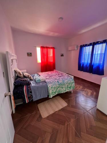 蓬塔卡纳Villa avec jardin的一间卧室配有床和红色窗帘