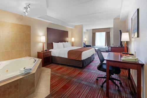 亨茨维尔马斯科卡贝斯维斯特酒店的酒店客房配有一张床、一张书桌和一个浴缸。