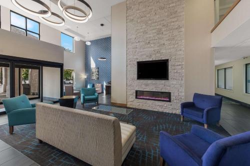 Tipp CityComfort Inn & Suites Tipp City - I-75的客厅配有沙发、椅子和壁炉