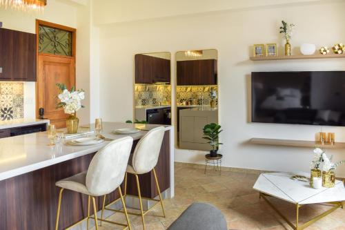 巴拿马城Modern luxury Studio with Rooftop + parking的厨房配有带白色椅子的酒吧和电视