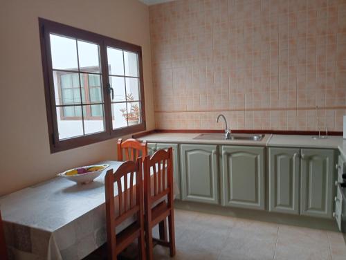 塞博河畔卡莱塔Casa Carmen Dolores的厨房配有桌椅和水槽。