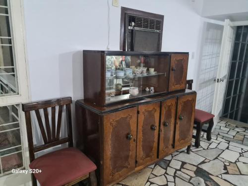 耶尔瓦布埃纳Casa Al pie del Cerro的旧木柜,房间带两把椅子