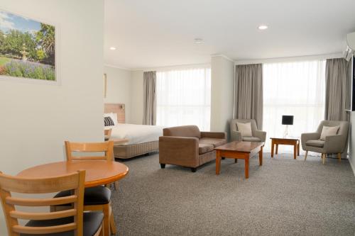 古尔本驿馆汽车旅馆的酒店客房带一张床、一张桌子和椅子