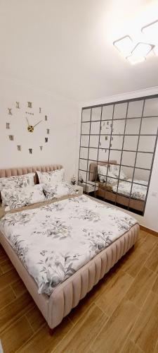 RoşuCozyStudio10的一间卧室配有一张大床,墙上挂着一个时钟