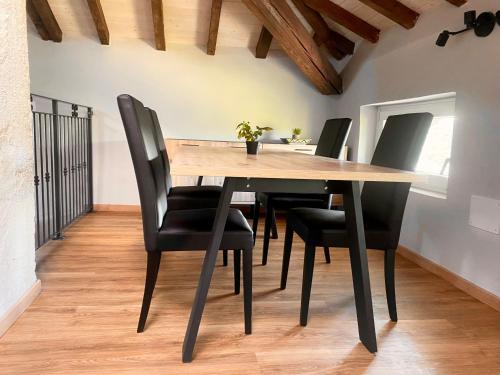 维罗纳Domus 44 Apartments的用餐室配有木桌和黑椅子