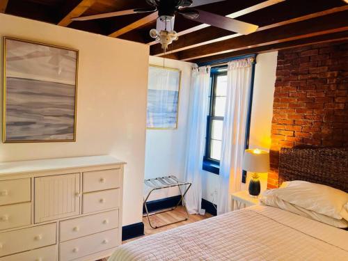 波特兰Host your group - West End Sea Captain Home的一间卧室配有一张床和吊扇