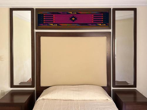 瓦哈卡市Hostal Nordés的一间卧室配有一张带两张桌子和一扇窗户的床。