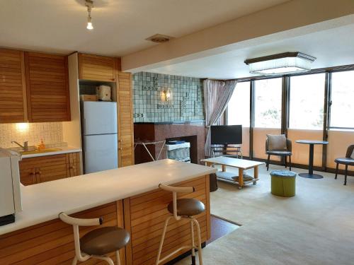 小樽Bay View House private room / Vacation STAY 3667的厨房以及带柜台和椅子的客厅。