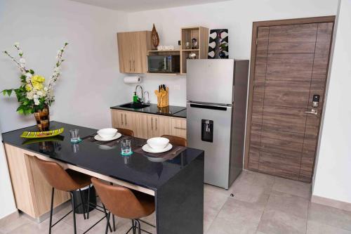 危地马拉Lovely 1 bedroom unit with free parking Modra zone 4的厨房配有黑桌和冰箱。