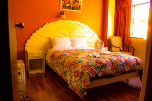 普诺ANDENES DEL TITICACA的一间卧室配有一张大床和彩色床罩