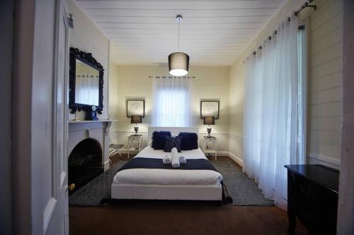 希尔斯维尔Inglenook Cottage Healesville的一间卧室设有一张大床和一个壁炉