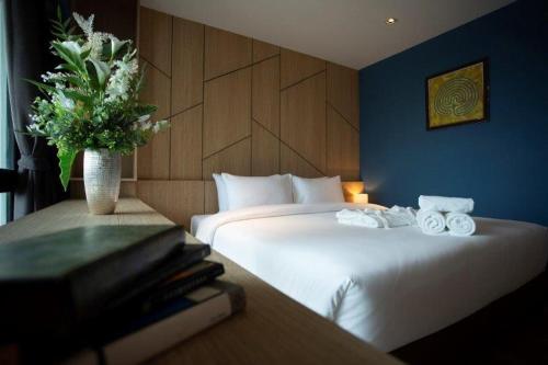 罗勇Hotel Fuse Rayong的酒店客房带两张床和花瓶