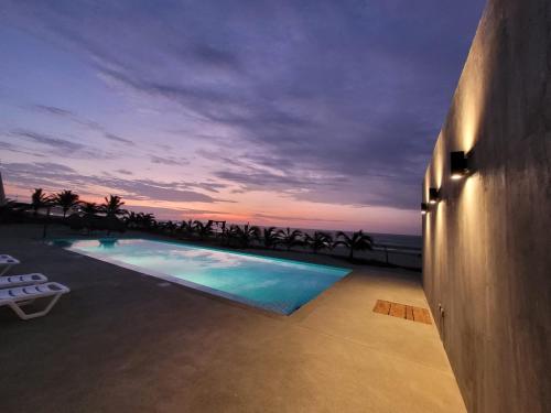 卡诺阿斯德蓬萨尔Las Hamacas的黄昏时可欣赏到海景的游泳池