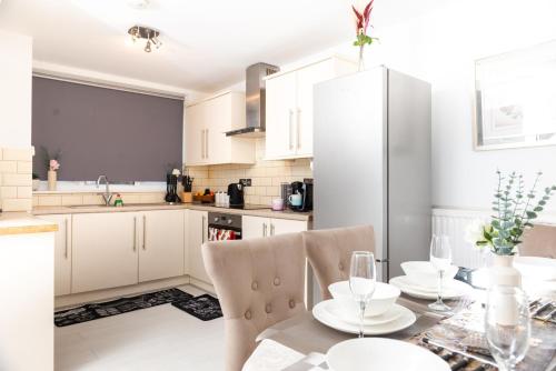 伦敦Spacious House near Kings Cross的厨房配有白色橱柜和桌椅
