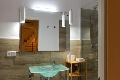 锡内乌Townhouse Sa Casa的一间带水槽和镜子的浴室