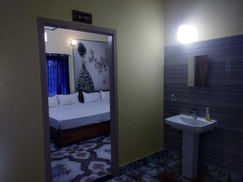 普里TITILI PLAZA的一间卧室配有床、水槽和镜子
