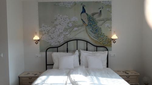 德恩巴赫Villa Franzen的卧室配有一张床铺,墙上挂有孔雀画