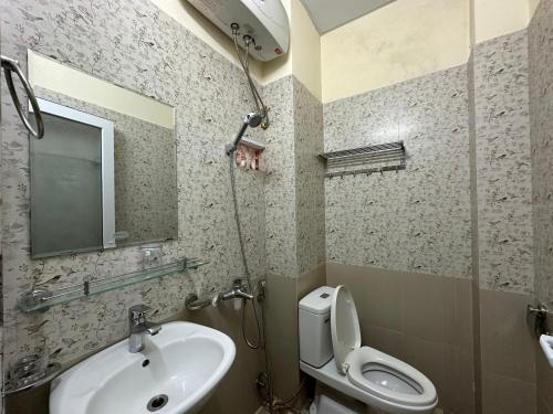 大叻OYO 1202 Ruby Motel Da Lat的一间带水槽、卫生间和镜子的浴室