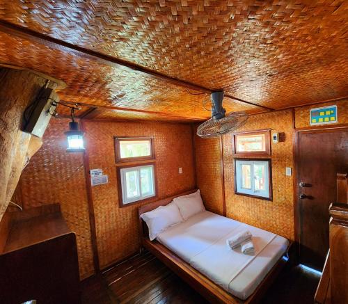 ItaytayUno Dus Tourist Inn的一间小卧室,房子里配有一张床铺