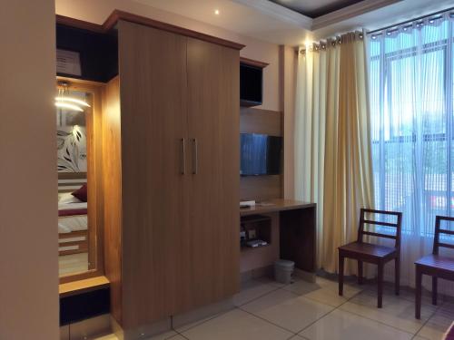PinangodeIvyArk Residency的一间卧室配有一张大木橱柜和书桌