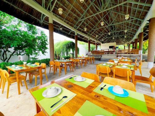 潘切Me Bungalow Beach Resort的餐厅设有木桌、椅子和桌椅