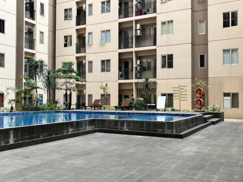 万隆Cozy 2 BR Sudirman Suites Apartment的大楼前的游泳池