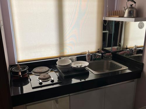 万隆Cozy 2 BR Sudirman Suites Apartment的厨房柜台配有炉灶和水槽