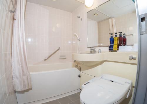 东京Saka no Hotel Tretio Ochanomizu的浴室配有卫生间、浴缸和水槽。