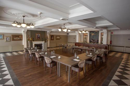 赫尔蒙德Golden Tulip West Ende的大房间设有一张长桌子和椅子