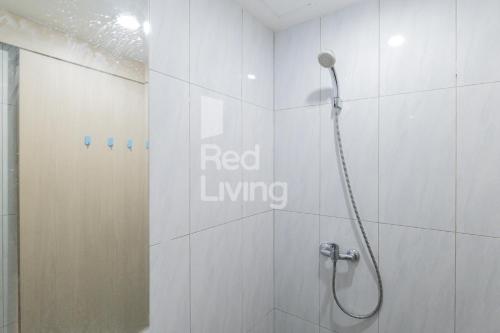 雅加达RedLiving Apartemen Jakarta Living Star - BoboRooms的浴室设有淋浴,墙上有红色的活标志
