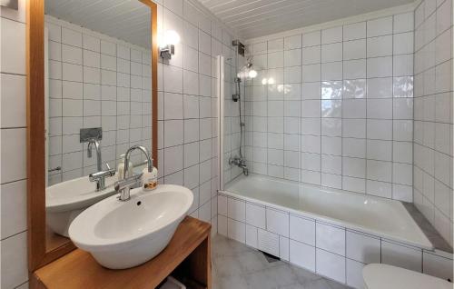 4 Bedroom Awesome Home In Strandvik的浴室配有盥洗盆和浴缸。