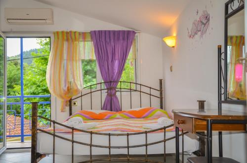 斯卡拉伯塔麦斯Studios Ifigenia的一间卧室配有一张床和一个带紫色窗帘的窗户