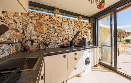 穆尔西亚Stunning Home In Murcia With Swimming Pool的厨房里的石墙,配有洗衣机和烘干机