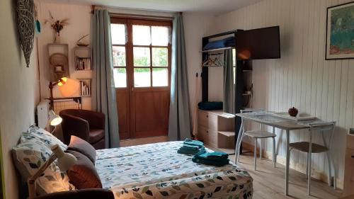 Foncine-le-HautLe Bois gentil的一间卧室配有一张床、一张桌子和一张书桌
