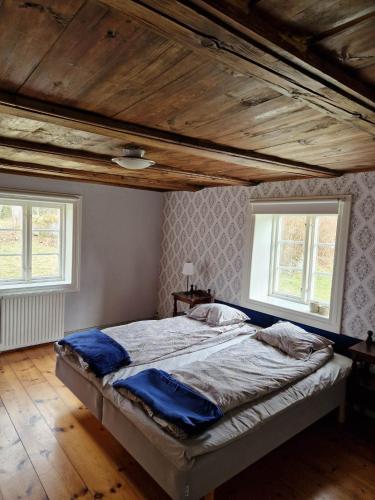 乌洛夫斯特伦Alltidhult的一张大床,位于带两个窗户的房间