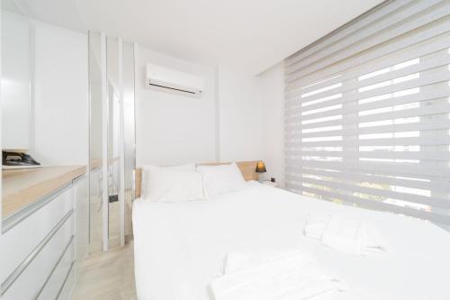 安塔利亚Residence w Shared Pool 3 min to Mall of Antalya的白色的卧室设有床和窗户
