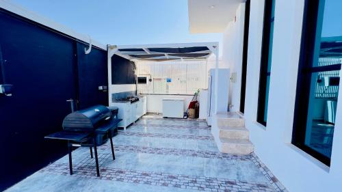 苏尔Wadi Shab Beach Villa的一间设有蓝色椅子和厨房的房间