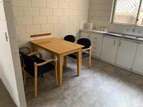杰拉尔顿Harbour View 49 Urch Street Unit 7的厨房配有木桌和椅子