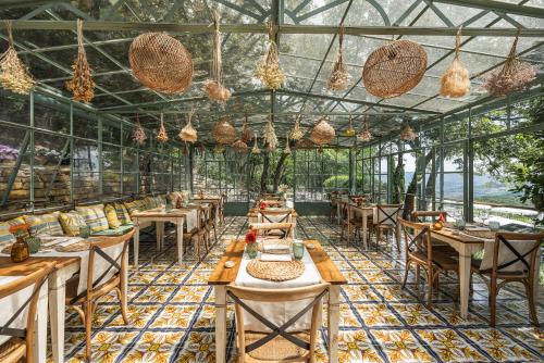 拉达-因基安蒂Borgo Vescine的温室里带桌椅的餐厅