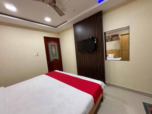 BhadrāvatiSTAYMAKER DV Residency的卧室配有一张床,墙上配有电视。
