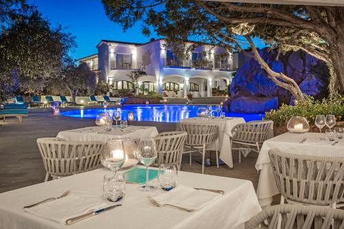 巴哈撒丁岛拉罗卡度假酒店及spa 的一间带白色桌椅的餐厅和一个游泳池