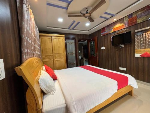 BhadrāvatiSTAYMAKER DV Residency的一间卧室配有一张床和吊扇
