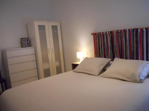 卡塞雷斯Naturalia: La casita con Patio的卧室配有白色的床和2个枕头