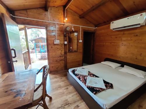 巴加Pousada Donaciana - Beach Cottages的小木屋内的卧室配有1张床和1张桌子