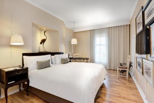 梅富根梅富根万豪Protea酒店的酒店客房设有一张白色大床和一张书桌