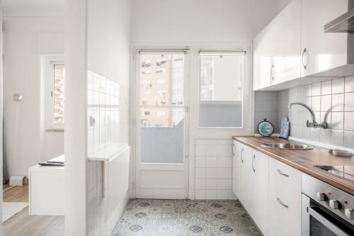 里斯本JOIVY Striking flat in Benfica的白色的厨房设有水槽和窗户