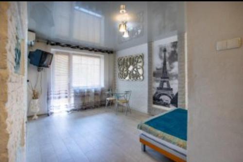 尼古拉耶夫Студия на проспекте Мира的一间卧室配有一张床、一张桌子和一个窗户。