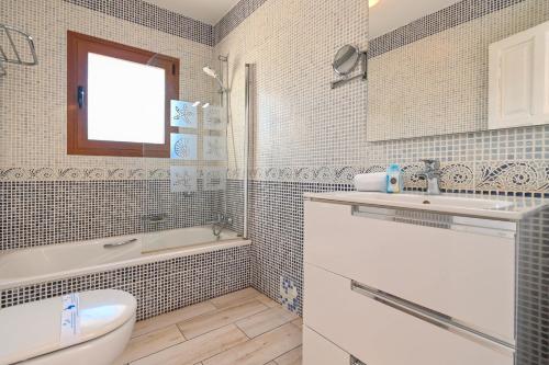 哈维亚雷纳度假屋的一间带水槽、浴缸和卫生间的浴室